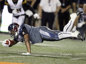 Alouettes receiver Nik Lewis dives for extra yards after making a catch against the Hamilton Tiger-Cats during Canadian Football League game in Montreal Friday July 15, 2016.