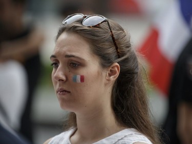 A woman looks on during a vigil in memory of the victims of Thursday's terror attack in Nice, France, outside the French consulate in Montreal on Saturday, July 16, 2016.