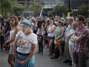 People take part in a vigil in memory of the victims of Thursday's terror attack in Nice, France, outside the French consulate in Montreal on Saturday, July 16, 2016.
