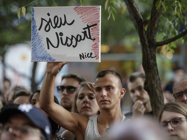 People take part in a vigil in memory of the victims of Thursday's terror attack in Nice, France, outside the French consulate in Montreal on Saturday, July 16, 2016.