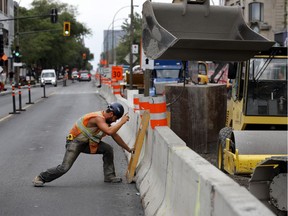 A worker moves concrete barriers on St-Denis St. as part of the year-long infrastructure project on the central downtown boulevard.