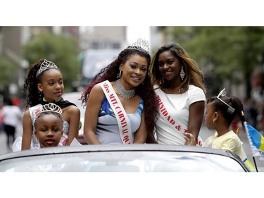 Miss MTL Carnival, centre, is driven down Sainte-Catherine street during the Carifiesta Parade in Montreal on Saturday July 2, 2016.