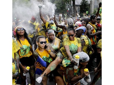 People dance as they follow a float with a Calypso DJ during the Carifiesta Parade in Montreal on Saturday July 2, 2016.