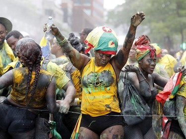 People dance as they follow a float with a Calypso DJ during the Carifiesta Parade in Montreal on Saturday July 2, 2016.