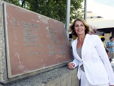 MONTREAL, QUE.: JULY 21, 2016 -- Nadia Comaneci poses for photos with a plaque at Olympic Park in Montreal Thursday July 21, 2016 detailing the winners in gymnastics at the 1976 Olympic Summer Games that here held in Montreal.  Comaneci was in Montreal to mark the 40th anniversary of the Games.  (John Mahoney} / MONTREAL GAZETTE) ORG XMIT: 56717 - 3907