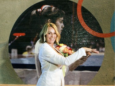 Then and now: Nadia Comaneci stops for a photo in front of a picture of herself competing in the 1976 Montreal Olympic Games during a visit to the Olympic Park to mark the 40th anniversary of the '76 Games in Montreal Thursday July 21, 2016. (John Mahoney} / MONTREAL GAZETTE) ORG XMIT: 56717 - 3155