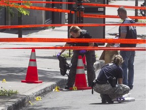 Montreal police investigators and crime scene detectives gather evidence on Mountain Street next to the place where an unidentified man was found in critical condition with severe head injuries on Friday July 22, 2016.