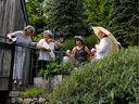 Pat Webster, second from left, speaks with guests, a group of gardeners who help look after the extensive gardens of her and Norman Webster's home in Sainte-Catherine-de-Hatley, in the Eastern Townships.