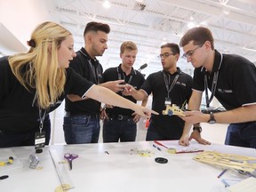 Felix Lamy is flanked by, from left, Rachel Kendall, Raymond Alexander, Santiago De La Rosa and Kevin Mazur as they confer on their car design at an Infiniti car dealership in Montreal during the Canadian finals for the Infiniti Engineering Academy on July 28, 2016. Lamy won the competition for a year-long placement to work with Infiniti and the Renault Sport Formula One Team.
