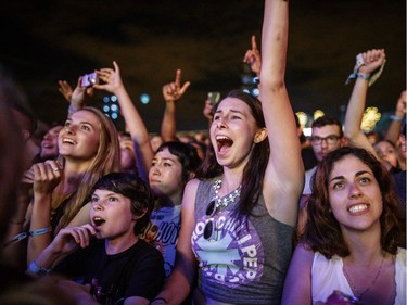 Music fans cheer during the set by Red Hot Chili Peppers on Day One of the Osheaga Music and Arts Festival at Parc Jean-Drapeau on Friday, July 29, 2016.
