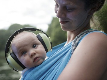 Zilia Lefebvre holds her seven month old son Roman as he wears ear muffs during Day One of the Osheaga Music and Arts Festival at Parc Jean-Drapeau in Montreal on Friday, July 29, 2016.