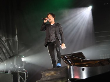 Jamie Cullum stands on the piano during the second of three big free outdoor blowout concerts at the Montreal International Jazz Festival on July 4, 2016.