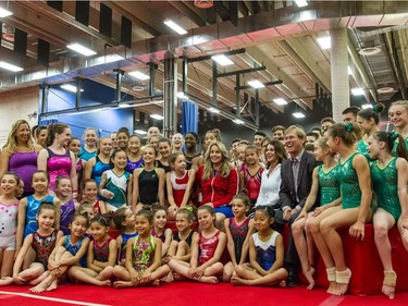Nadia Comaneci, in white, poses for a photograph alongside husband Bart Conner and Canadian Olympic bronze medal diver Annie Pelletier, to her right, along with young athletes at the Institut national du sport du Québec at the Olympic Stadium in Montreal on July 8, 2015.