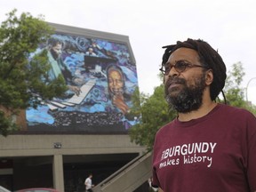Michael Farkas in the Little Burgundy area of Montreal in front of a mural called Jazz Born Here with images depicting jazz great Oscar Peterson.