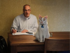 Jeffrey Davies with his cat Vanilla in the dining room area on June 7, 2016. Davies has three cats, which he calls the "coffee contingent'! They're named Vanille, Moka and Noisette. This is a double living room/bedroom and throughout, several pieces of custom-made furniture, notably the stereo stand, coffee table and in the dining table, made of beautiful, grained walnut — a recent purchase.