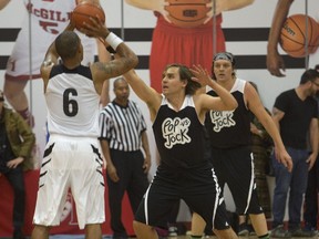 Arcade Fire's Will Butler, centre, and Win Butler, right, take part in the 2014 edition of the POP vs. Jock basketball game at McGill University Sports Centre.