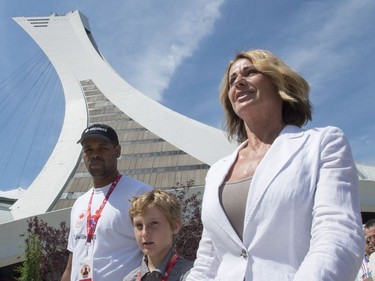 Montreal 1976 Olympics gymnastics champion Nadia Comaneci and her son Dylan walk past Olympic Stadium as she tours a exhibit marking the 40th anniversary of the Games Thursday, July 21, 2016 in Montreal.