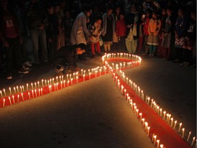 Nepalese women and children from "Maiti Nepal", a rehabilitation center for victims of sex trafficking, light candles on the eve of World AIDS Day in Kathmandu, Nepal, Monday, Nov. 30, 2015. World AIDS Day is observed on December 1 every year to raise the awareness in the fight against HIV.
