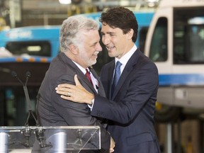 Prime Minister Justin Trudeau, right, shakes hands with Quebec Premier Philippe Couillard after making an infrastructure announcement at a municipal bus depotTuesday, July 5, 2016 in Montreal.