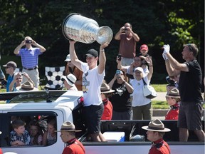 Pittsburgh Penguins' Sidney Crosby hoists the Stanley Cup during a parade through his hometown of Cole Harbour, N.S., on Saturday, July 16, 2016.