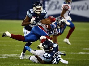 T.J. Heath of the Toronto Argos takes out Nik Lewis of the Montreal Alouettes during CFL action at BMO Field in Toronto on Monday.