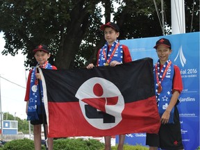 Team Lac St-Louis sailors swept the podium in the Quebec Games' 15-and-under sailing event, June 24, at the Royal St. Lawrence Yacht Club in Dorval. Gold medal-winner Eric Omielan, centre, of Dorval proudly holds his team's flag, flanked by silver medallist Jean-René Kiekans-Arana, left, and bronze medalist William Lloyd during medal-presentation ceremonies. (Photo Peter Varga)