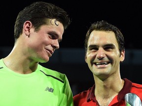Roger Federer of Switzerland and Milos Raonic (L) of Canada smile during the prize giving ceremony of the men's single final of the Brisbane International tennis tournament in Brisbane on Jan. 11, 2015.