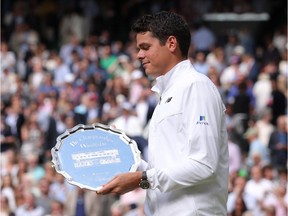 Canada's Milos Raonic poses with the runners up plate after losing the men's singles final to Britain's Andy Murray on the last day of the 2016 Wimbledon Championships at The All England Lawn Tennis Club in Wimbledon, southwest London, on July 10, 2016.