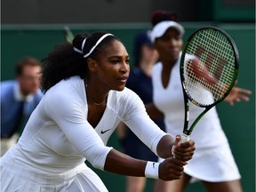 Serena Williams, left, and Venus Williams play against Russia's Ekaterina Makarova and Elena Vesnina during their women's doubles quarter-final match on the eleventh day of the 2016 Wimbledon Championships at The All England Lawn Tennis Club in Wimbledon, southwest London, on July 7, 2016. /