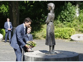 Canadian Prime Minister Justin Trudeau and his son, Xavier pay their respects to the victims of the 1932-1933 great famine at the Holodomor famine memorial in Kyiv, Ukraine, on July 11, 2016