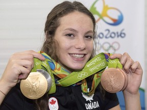 Canada's Penny Oleksiak, from Toronto, holds up her four medals, a gold, silver and two bronze, she won at the 2016 Summer Olympics during a news conference Sunday, August 14, 2016 in Rio de Janeiro, Brazil.