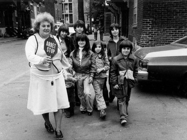 1979: A finely dressed Gita Gagnon leads a group of cool-looking city kids across the street. She was one of 32 people who were awarded bravery medals in Ottawa that day.  The long collars and wide-bottom pants of the 70s are not gone yet.