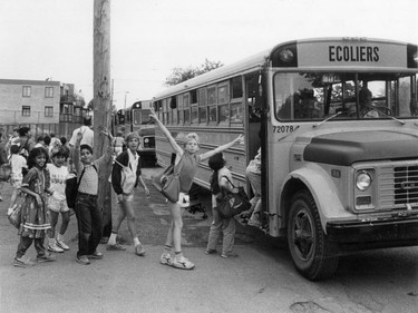1987: Bishop Whelan High School students have their transportation back after about 750 Transco bus drivers ended their seven-week walkout. A wide variety of bags being carried. They must not be getting a lot of homework. Shorts are very short and loose.