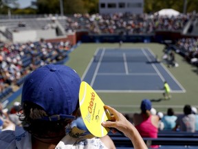 A spectator shades his face from the sun while watching the first round of the U.S. Open n New York.