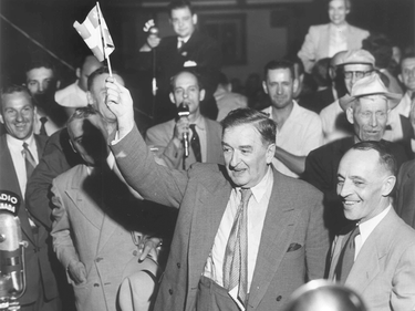Université de Montréal alumnus Maurice Duplessis waves the Quebec flag after being elected Premier in 1952, while Radio-Canada reporter and future premier René Lévesque reports from behind.