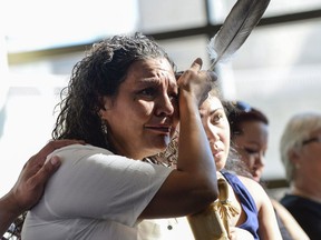 Ceejai Julian, who lost two sisters, wipes her eye during the announcement of the inquiry into Murdered and Missing Indigenous Women at the Museum of History in Gatineau, Quebec on Wednesday, Aug. 3, 2016. The federal government has announced the terms of a long-awaited inquiry into murdered and missing indigenous women, unveiling that it will need at least $13.8 million more for the study than was originally expected.