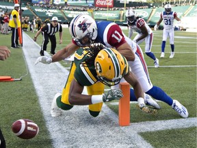 Montreal Alouettes' Chip Cox (11) tackles Edmonton Eskimos' Derel Walker (87) as he drops the ball before on the touchdown line during first half CFL action in Edmonton on Thursday, August 11, 2016.