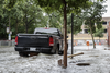 A vehicle is surrounded by water on Brewster avenue near the corner of St-Antoine street at the scene where a water main break caused flooding in the borough of St-Henri in Montreal on Saturday, August 13, 2016.