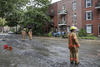 Firefighters walk through a flooded Brewster avenue near the corner of St-Antoine street at the scene where a water main break caused flooding in the borough of St-Henri in Montreal on Saturday, August 13, 2016.