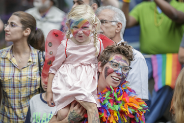 A woman and a child watch the the Montreal Pride Parade through Rene-Levesque boulevard in downtown Montreal on Sunday, August 14, 2016.