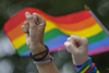 People raise their fists as they take part in a moment of silence during the Montreal Pride Parade through Rene-Levesque boulevard in downtown Montreal on Sunday, August 14, 2016.