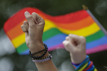 People raise their fists as they take part in a moment of silence during the Montreal Pride Parade through Rene-Levesque boulevard in downtown Montreal on Sunday, August 14, 2016.