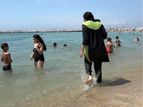 In Marseille, France, Nissrine Samali, 20, wades into the water wearing a burkini.