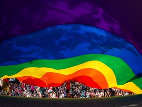 A large rainbow flag is carried down Robson Street during the Vancouver Pride Parade in Vancouver, B.C., on Sunday, August 2, 2015.