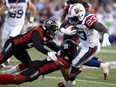 Ottawa Redblacks' Forrest Hightower (23), centre, and Nicholas Taylor (28) tackle Montreal Alouettes' Brandon Rutley (23) during first half CFL action on Friday, Aug. 19, 2016 in Ottawa.