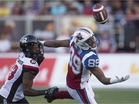 The ball drops out of reach of Montreal Alouettes wide receiver Duron Carter, right, as Ottawa Redblacks defensive back Forrest Hightower covers during second quarter CFL football action in Montreal on Thursday, June 30, 2016.