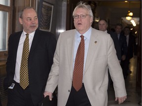 Jean-Louis Dufresne, left, Premier Philippe Couillard's chief of staff, and Health Minister Gaétan Barrette walk from a caucus meeting, Thursday, March 10, 2016 in Quebec City.