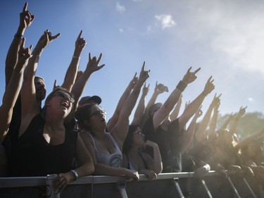 Music fans cheer during the performance by the American rock band Alter Bridge on Day Two of the Heavy Montréal music festival at Jean-Drapeau Park in Montreal on Sunday, August 7, 2016.