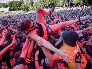 A woman crowd surfs during the performance by the American metalcore band Killswitch Engage on Day Two of the Heavy Montréal music festival at Jean-Drapeau Park in Montreal on Sunday, August 7, 2016.