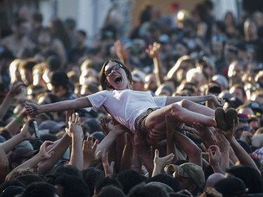 A woman crowd surfs during the performance by the American metalcore band Killswitch Engage on Day Two of the Heavy Montréal music festival at Jean-Drapeau Park in Montreal on Sunday, August 7, 2016.